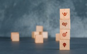 Conceptual of business with wooden blocks column with icons on dark color background side view. free space for your text horizontal image